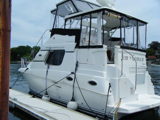 Silverton 322 Motor Yacht docked with an Atlantic Towers Top enclosure covering the upper deck controls and seating area.