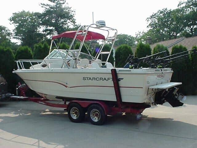 Starcraft 2314 Walkaround boat with a red canopy and Atlantic Towers Arch on a twin-axle trailer outdoors.