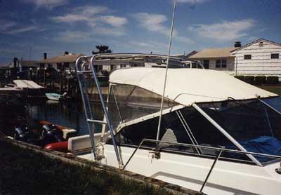 Atlantic Towers Arch installed on a Carver 26 Montego boat at a marina with other boats in the background.