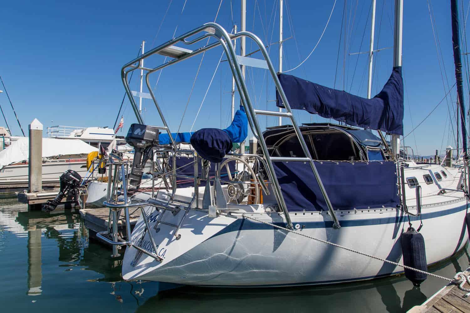 Sailboat docked in marina with Canadian Sailcraft brand and installed Atlantic Towers Arch visible on the stern under clear sky.