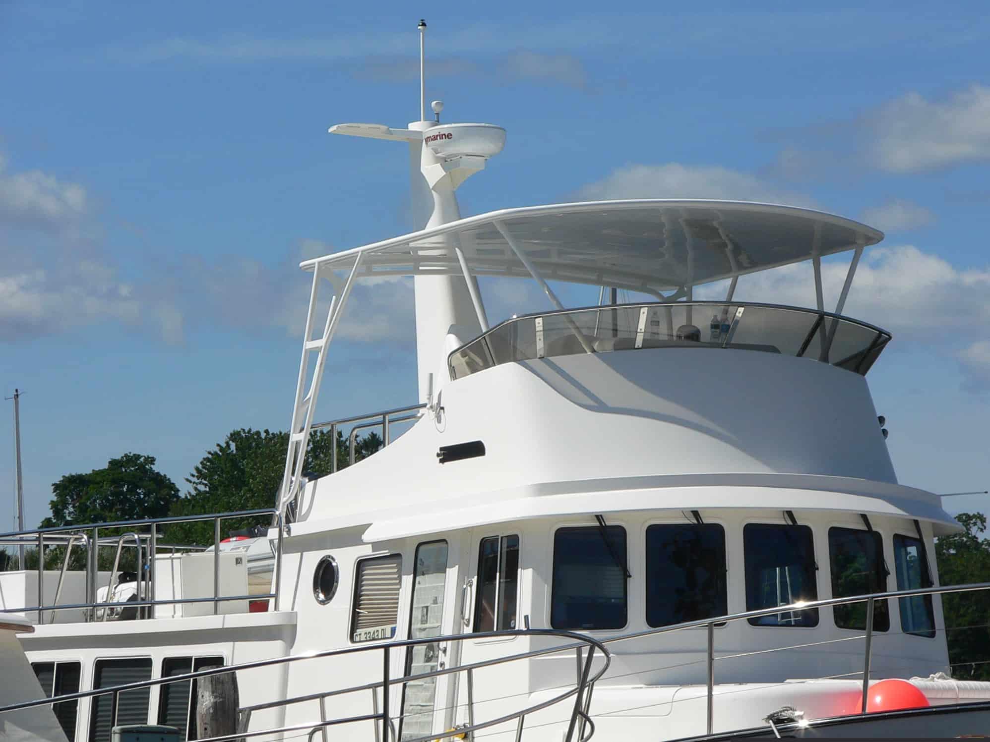 Atlantic Towers Top installed on a Nordic Tugs boat, featuring a sleek, white design against a clear blue sky.