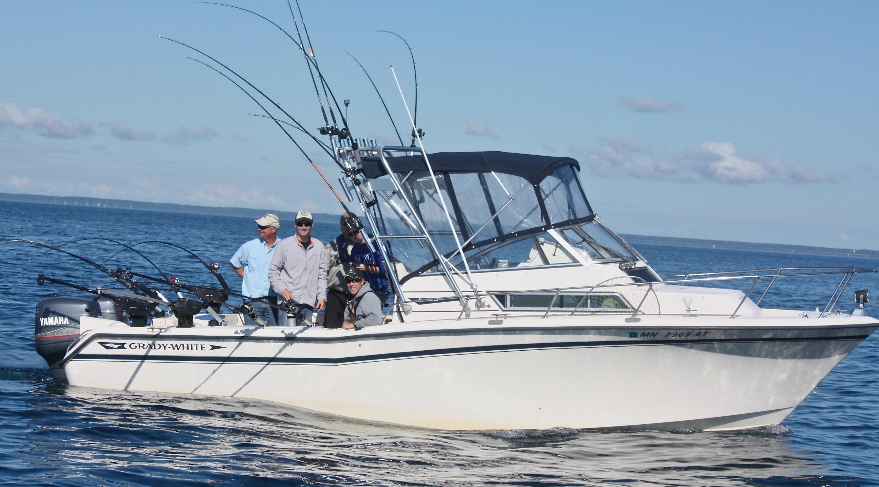 Four people on a Grady White boat with an Atlantic Towers Arch, fishing on a sunny day in the ocean.