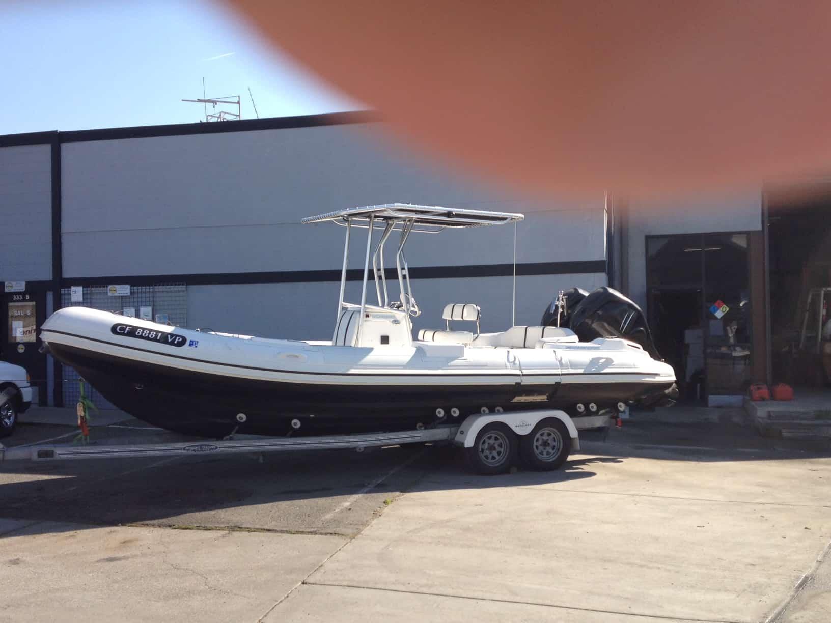 Atlantic Towers T-Top installed on a Nautica RIB boat, parked on a trailer outside a warehouse.