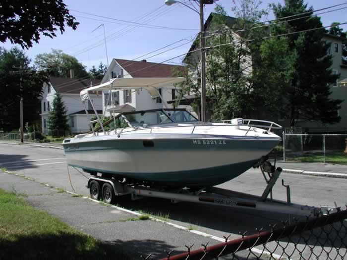 Atlantic Towers Top installed on a Chris Craft Scorpian boat, parked on a trailer near residential buildings.