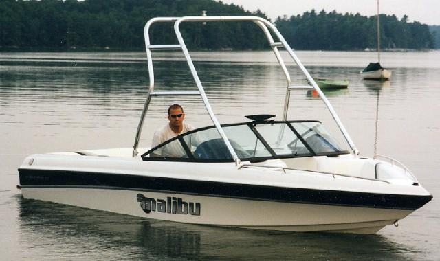 A Malibu Sunsetter LX boat equipped with an Atlantic Towers Air Tower, cruising on calm waters.