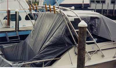 Atlantic Towers Arch installed on covered Silverton 31 Gulfstream boat docked beside a wooden piling with other boats nearby.