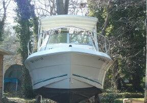 Atlantic Towers Top installed on white Aquasport 215 boat with cabin, surrounded by trees in outdoor setting.