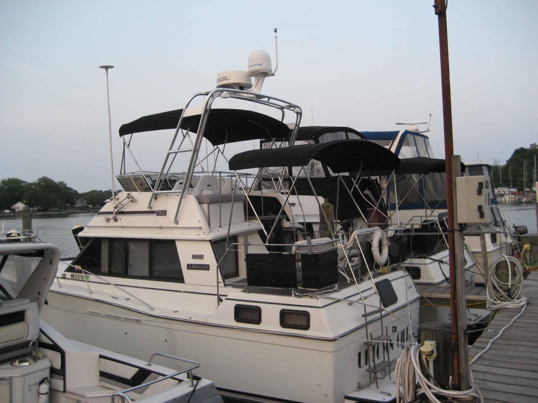 Atlantic Towers arch installed on Carver 3207 Aft Cabin boat docked beside other boats at marina in calm water.