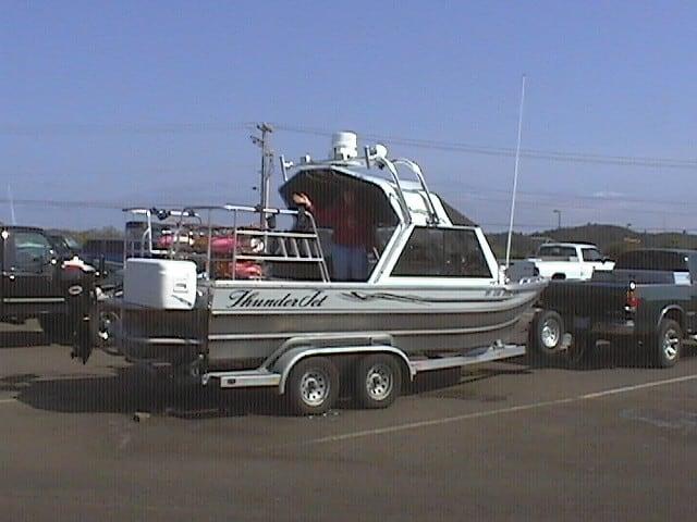 Thunder Jet Alexis Classic boat equipped with Atlantic Towers Arch mounted on a dual-axle trailer in a parking lot.