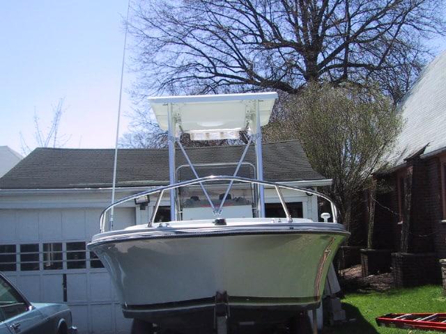 Front view of a Wellcraft Fisherman boat equipped with an Atlantic Towers T-Top, parked in a driveway.