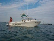 Atlantic Towers Arch installed on a Sportcraft 232 GLS boat, floating on calm water under a cloudy sky.