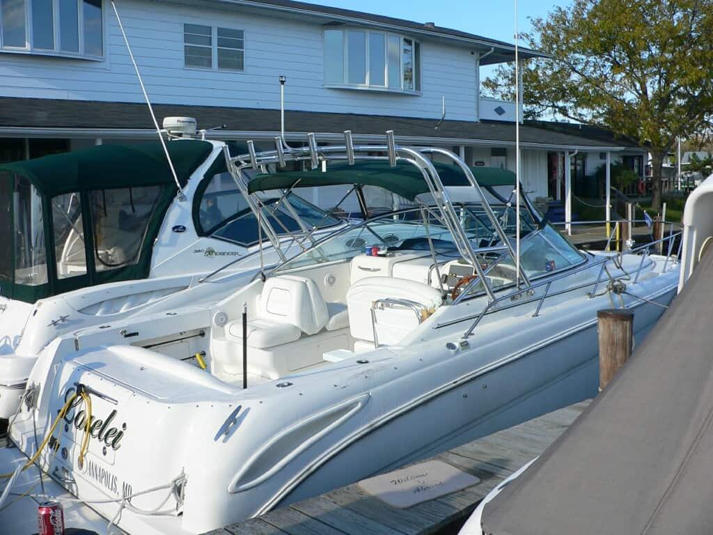 Sea Ray 290 Amberjack boat docked with Atlantic Towers arch and green canvas covering the cockpit area.