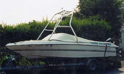 Four Winns 195 Sundowner boat with installed Atlantic Towers Air Tower on trailer near bushes and houses