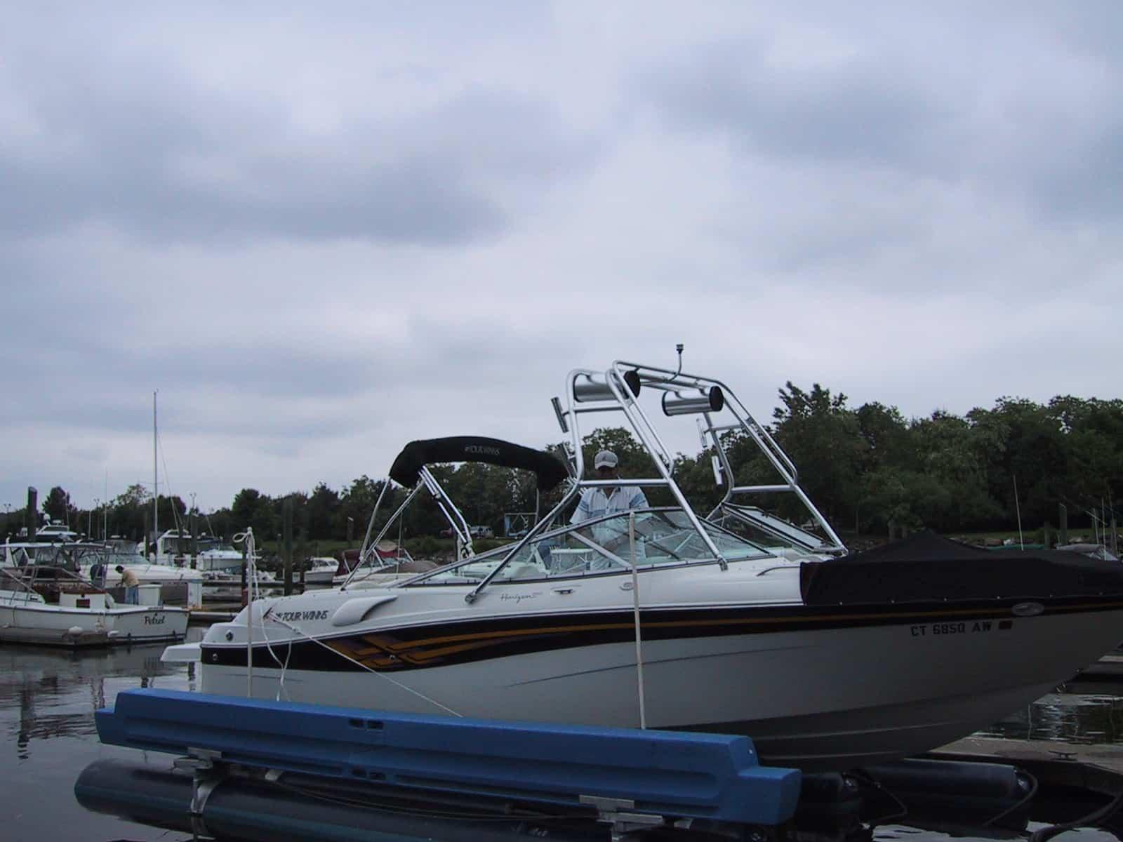 Atlantic Towers Air Tower installed on a Four Winns 260 Horizon boat at a marina under cloudy skies.