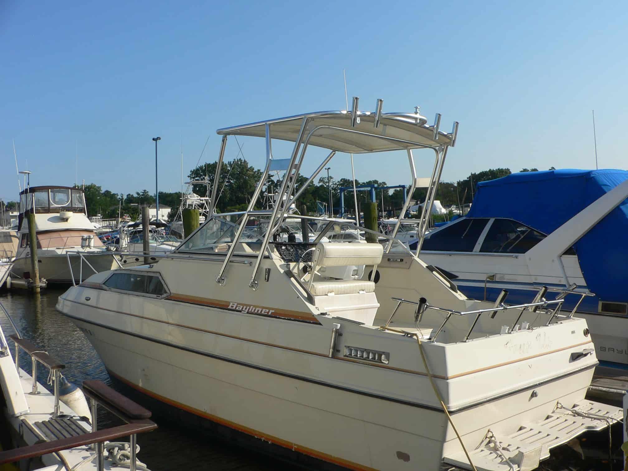 Atlantic Towers Top installed on a Bayliner 2750 Victoria boat docked in a marina under a clear blue sky.