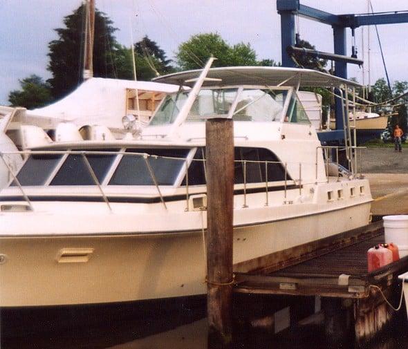 Bertram Motoryacht docked with Atlantic Towers Top installed above the helm area, view from the side at a marina.