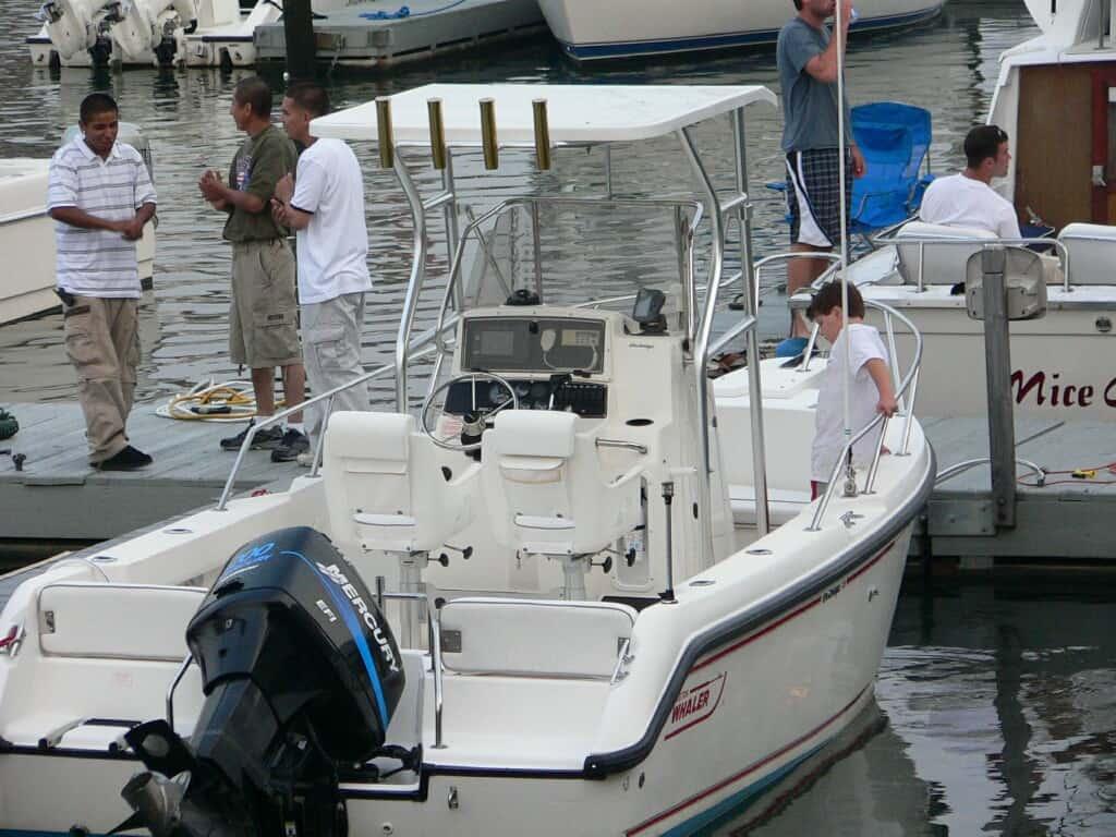 Atlantic Towers T-Top installed on a Boston Whaler 210 Outrage with people interacting by the dock.