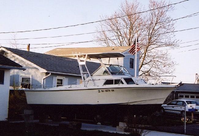 Atlantic Towers Top installed on a Stamas V24 boat parked near a residential building with trees in the background.