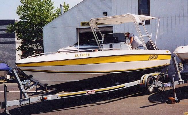 Wellcraft 26 Scarab Sportster boat with yellow stripe on trailer equipped with Atlantic Towers arch and canopy.
