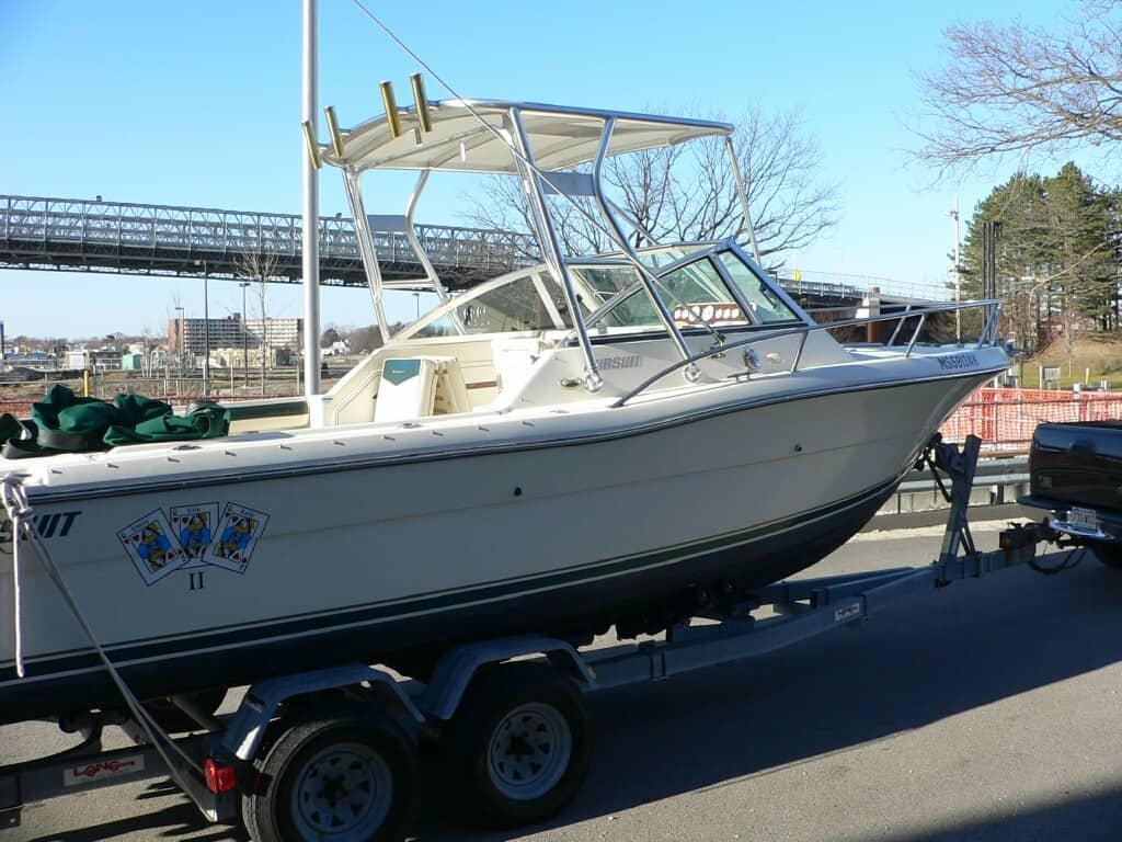 Atlantic Towers top installed on a Pursuit 2460 Denali boat, showcasing the vessel on a trailer in a parking area.