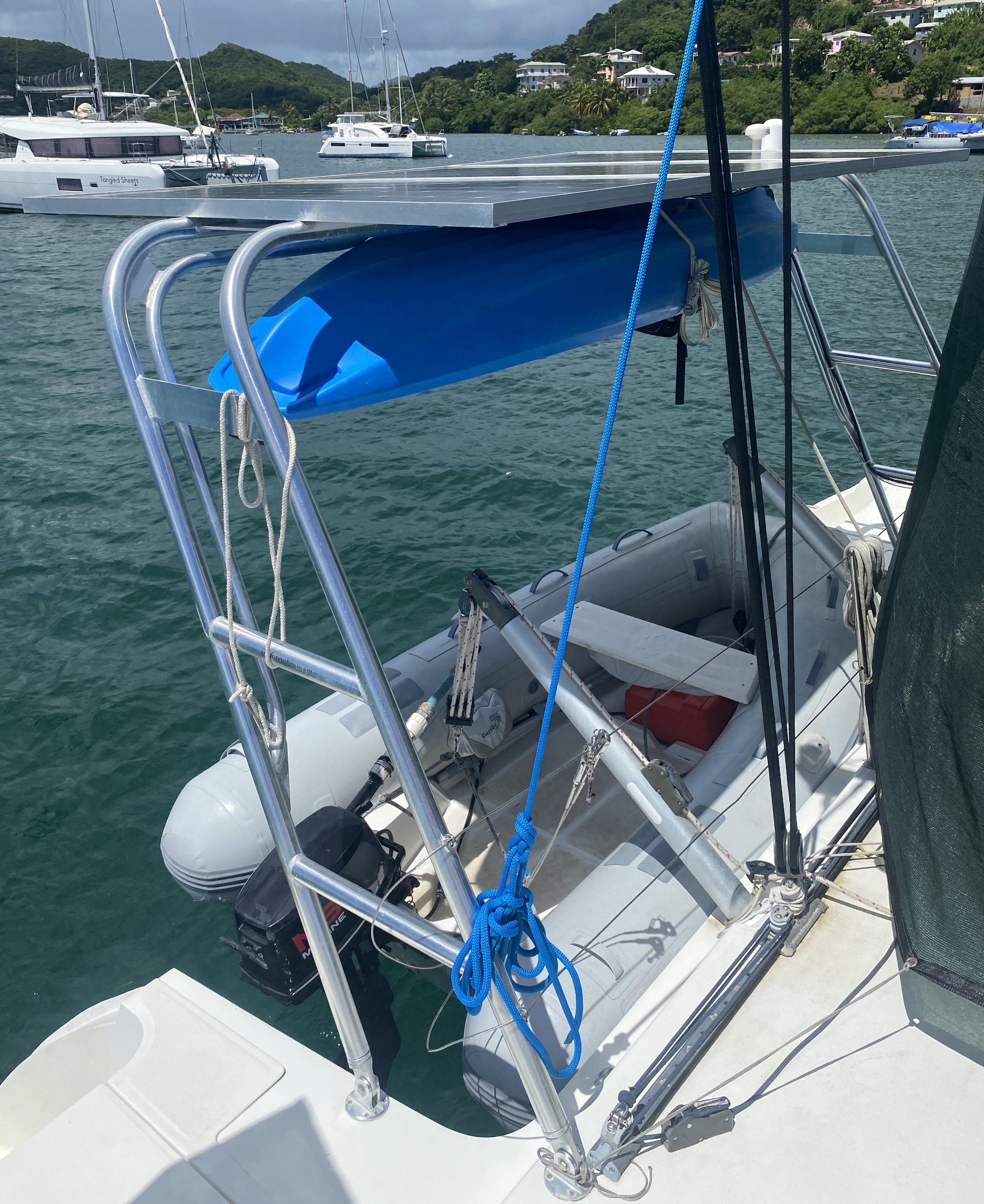Atlantic Towers Arch installed on a boat, holding a blue kayak above a dinghy in a marina setting.