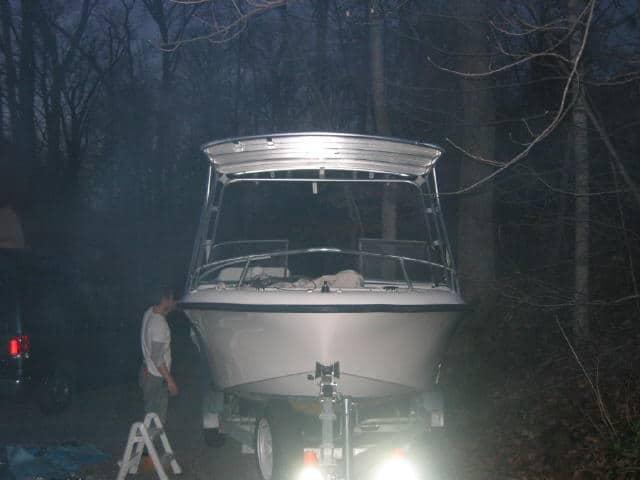 Mako 195 Dual Console boat equipped with Atlantic Towers Top on trailer in wooded area during dusk.