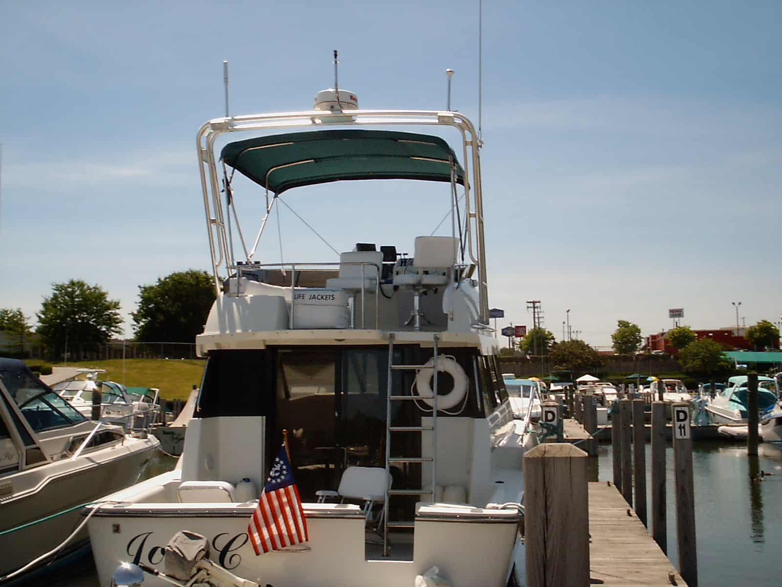 Atlantic Towers Arch on a Silverton 34 C boat at the marina, featuring a green canopy and life jackets visible.