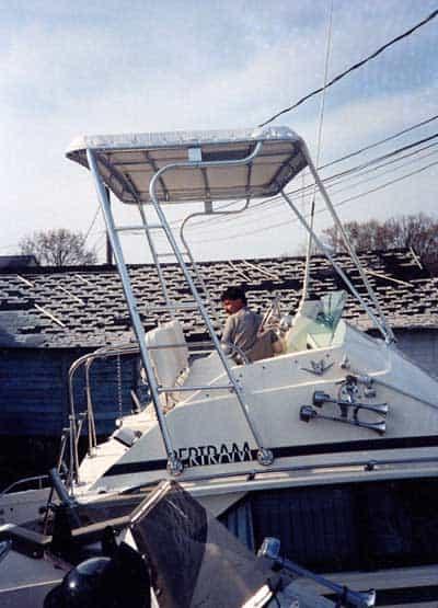 Atlantic Towers Top installed on a Bertram 28 Flybridge Cruiser with a person at the helm under a clear sky.