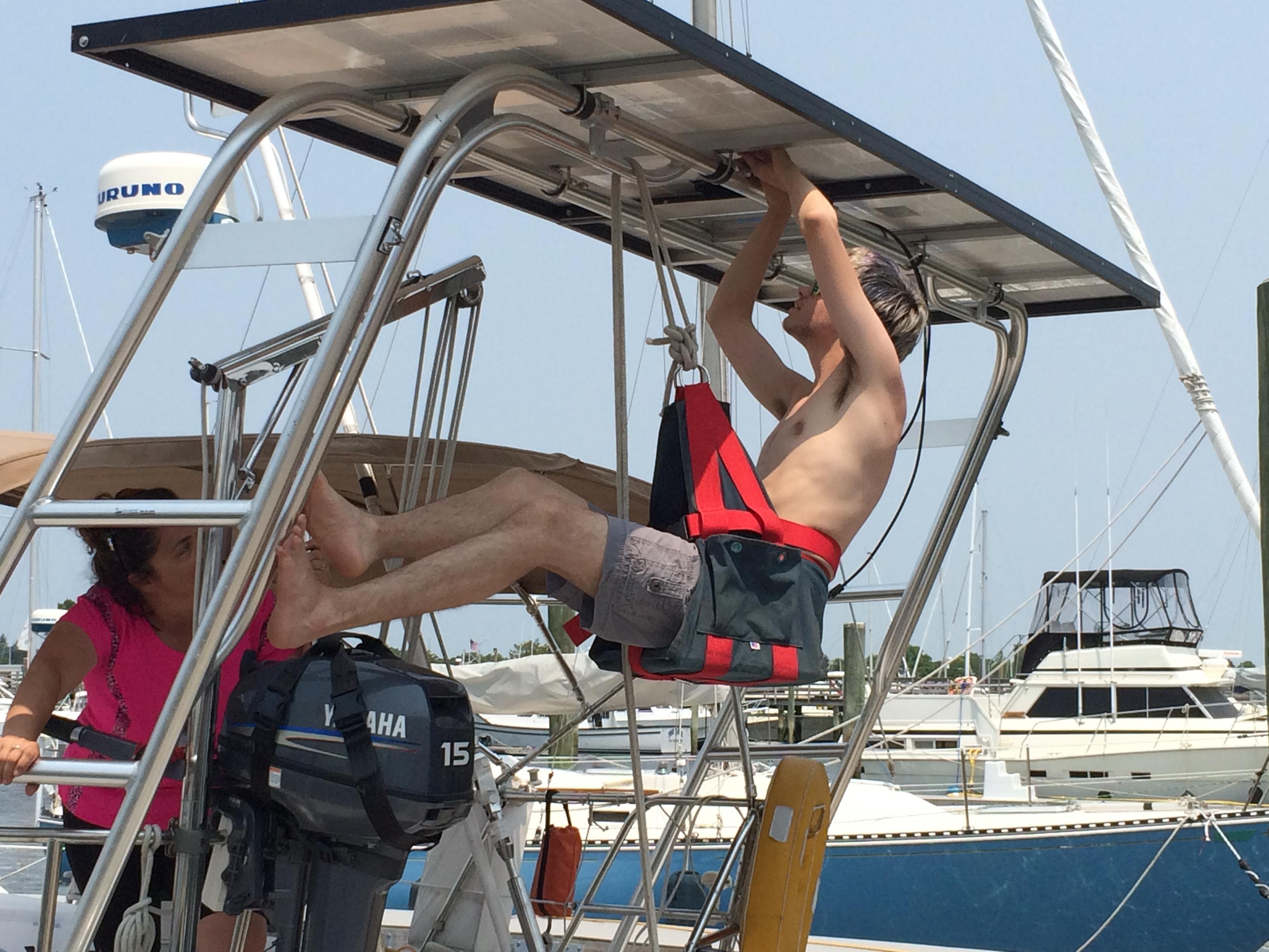 A person working on an Atlantic Towers Arch aboard a boat, with another individual assisting nearby.