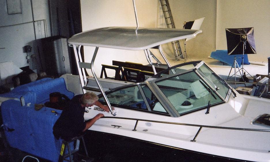 Man installing Atlantic Towers Top on Pursuit 2460 Denal1 boat indoors with studio equipment in background