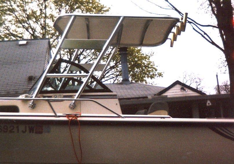 Side view of a Pro Line 23 W/A boat with an installed Atlantic Towers Top over the cockpit area in a residential backyard.