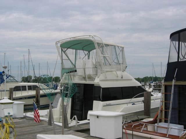 Silverton 37 Convertible yacht docked with Atlantic Towers Arch and green canvas flybridge enclosure on a cloudy day