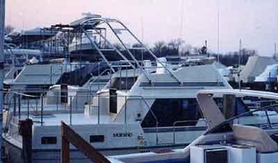 Atlantic Towers Arch installed on a Mainship 36 Double Cabin boat at a marina with other vessels in view.
