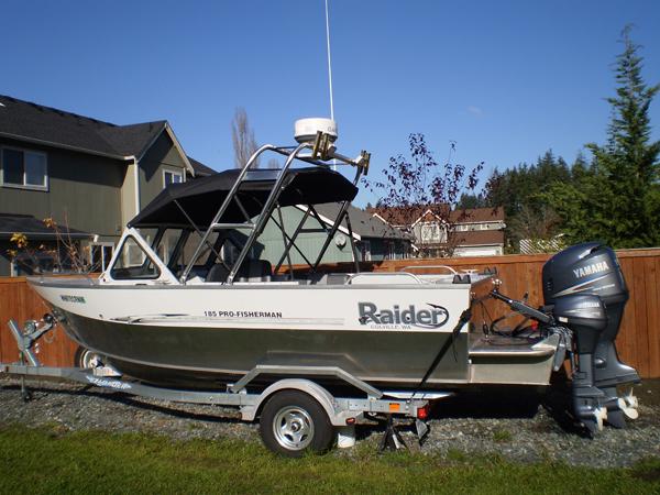 Raider 185 Pro boat on trailer with Atlantic Towers Arch and Yamaha outboard motor parked in a residential yard