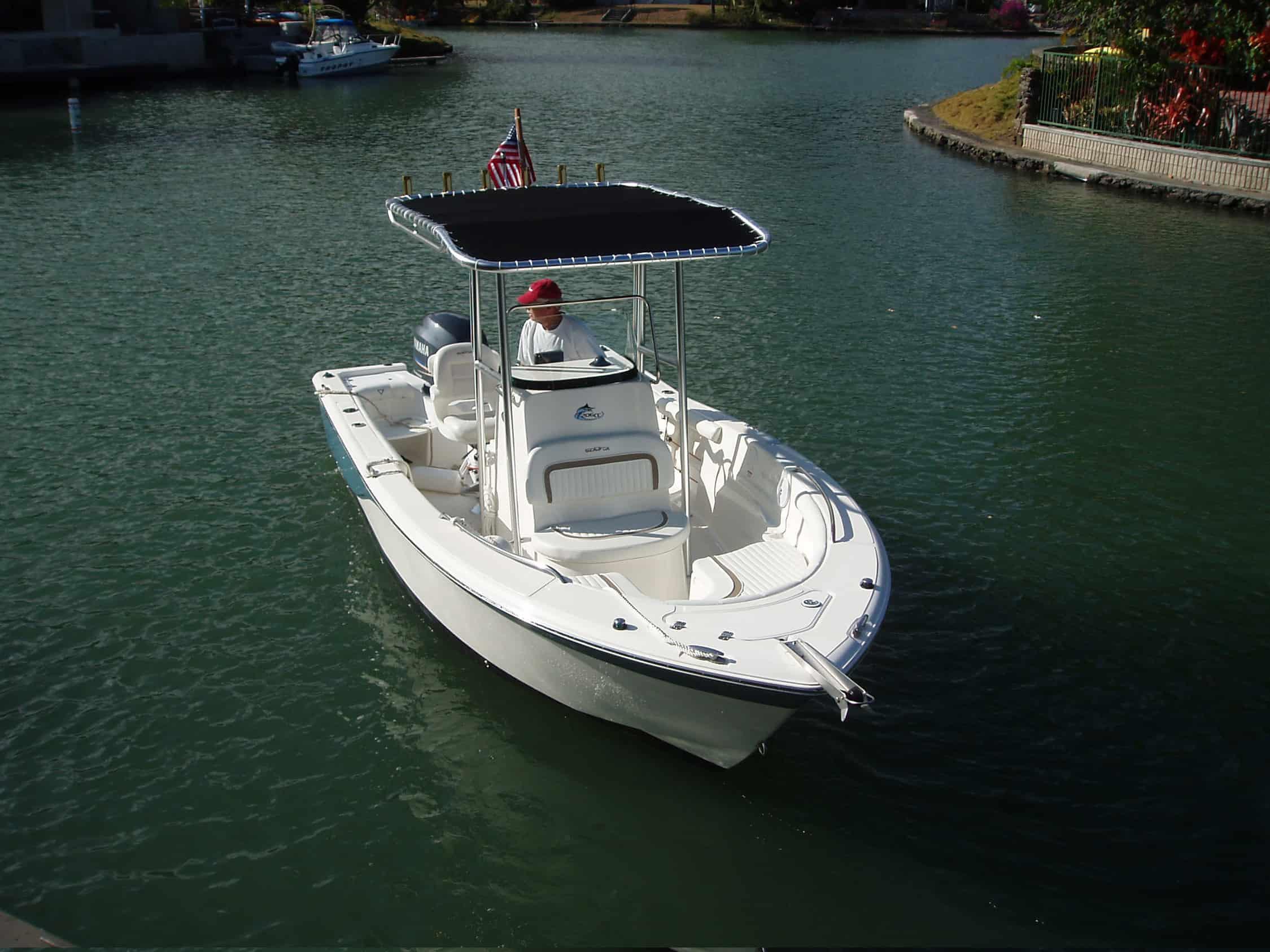 Sea Fox 206 boat on water with a man inside and an installed Atlantic Towers T-Top canopy with rod holders