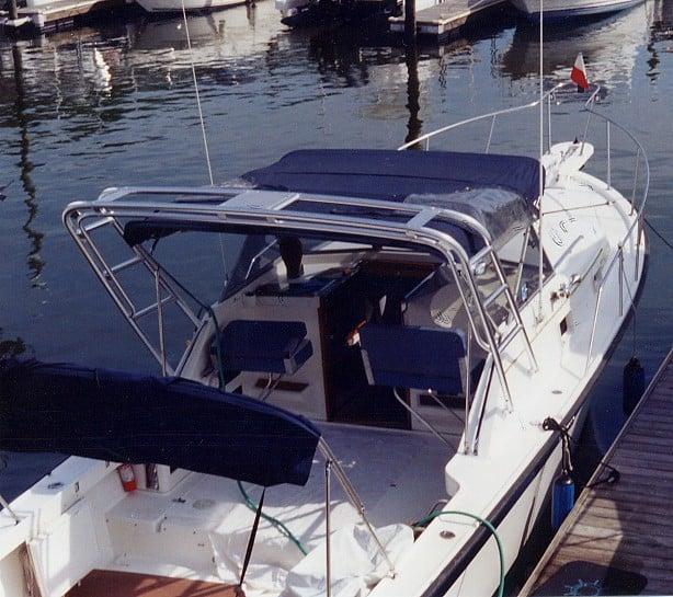 Alura 30 boat docked with installed Atlantic Towers Arch and blue canvas canopy over the cockpit area