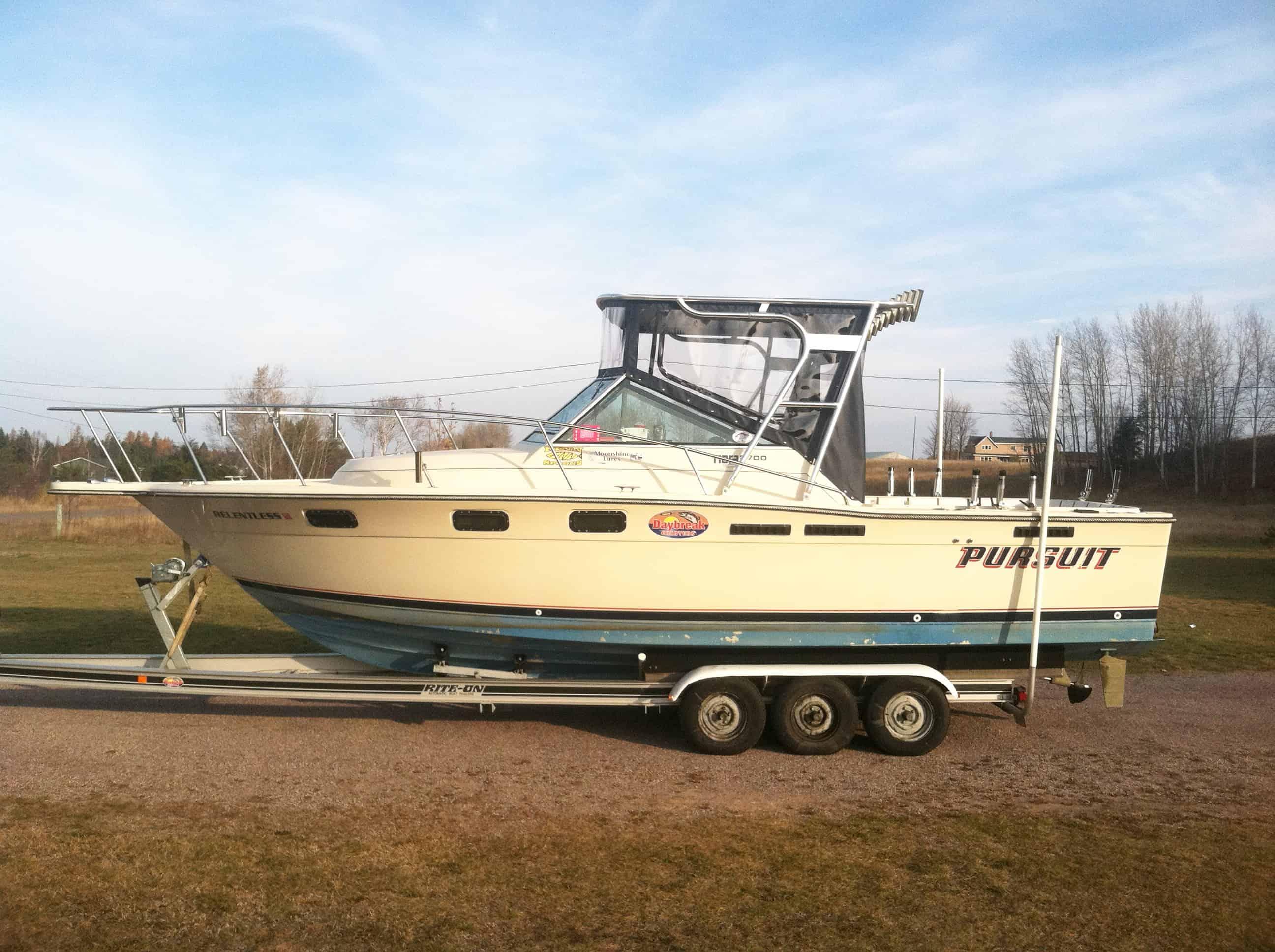 Atlantic Towers Top installed on a Tiara 2700 Pursuit boat, parked on a trailer in a grassy area.