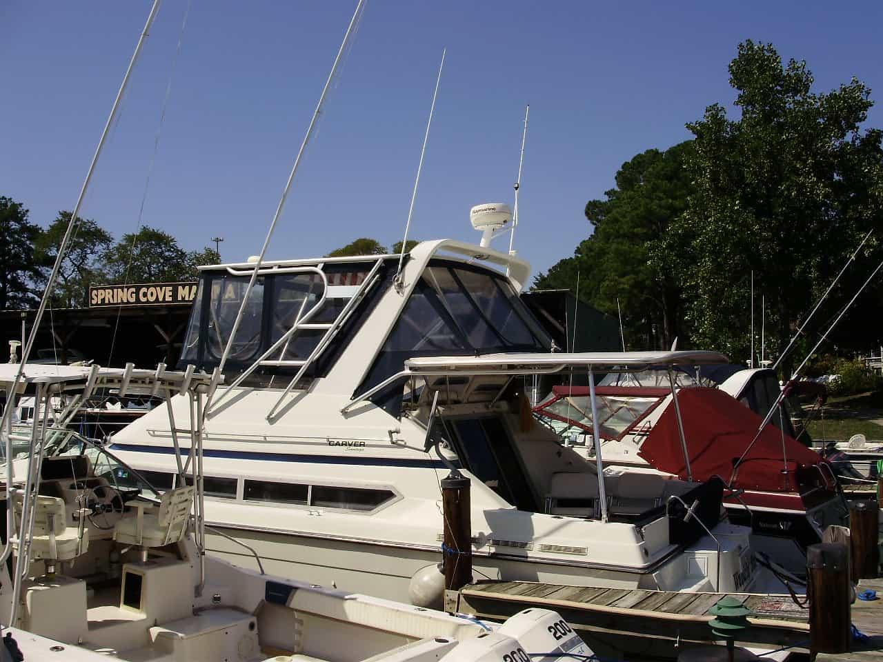Atlantic Towers Cockpit Sun Shade installed on Carver 34/638/380 Santego boat docked at a marina with other boats nearby.