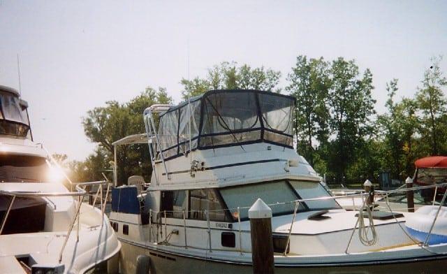 Atlantic Towers Aft Deck Top installed on a Carver 36 Aft Cabin boat docked near trees and other vessels.