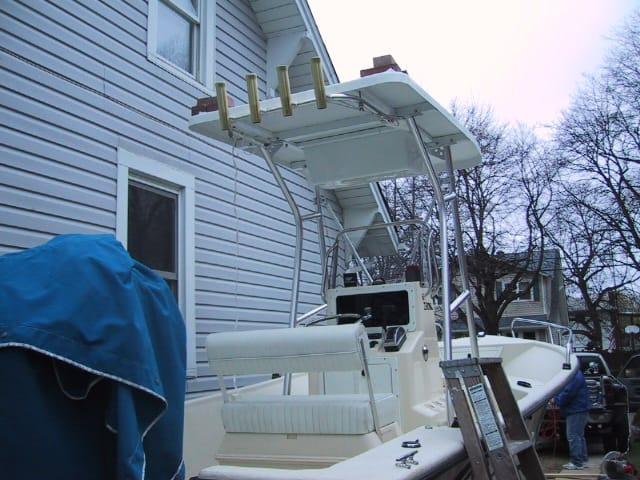 May Craft Console boat with Atlantic Towers T-Top installed, shown docked beside a residential house.