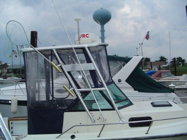 Atlantic Towers Top installed on a Pro Line 21 boat at a marina, featuring a clear enclosure and fishing net.