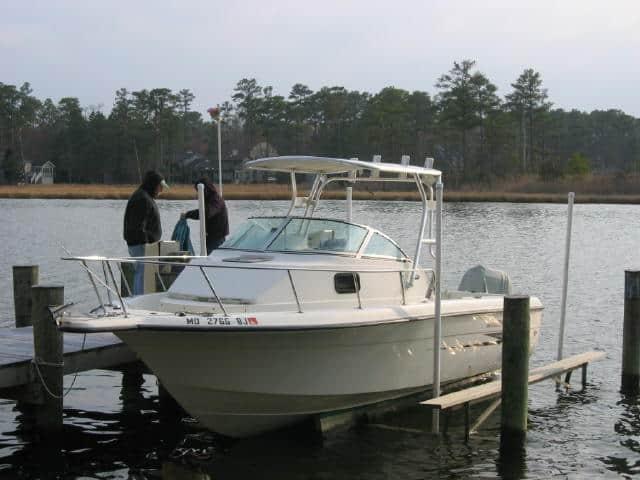 Hydra Sports 23 Walkaround cuddy boat docked with installed Atlantic Towers Top in a calm waterfront setting.