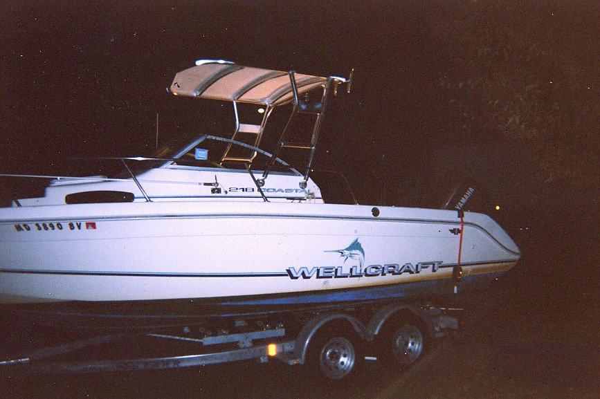 Wellcraft 218 Coastal boat with installed Atlantic Towers Top mounted on a trailer at night.