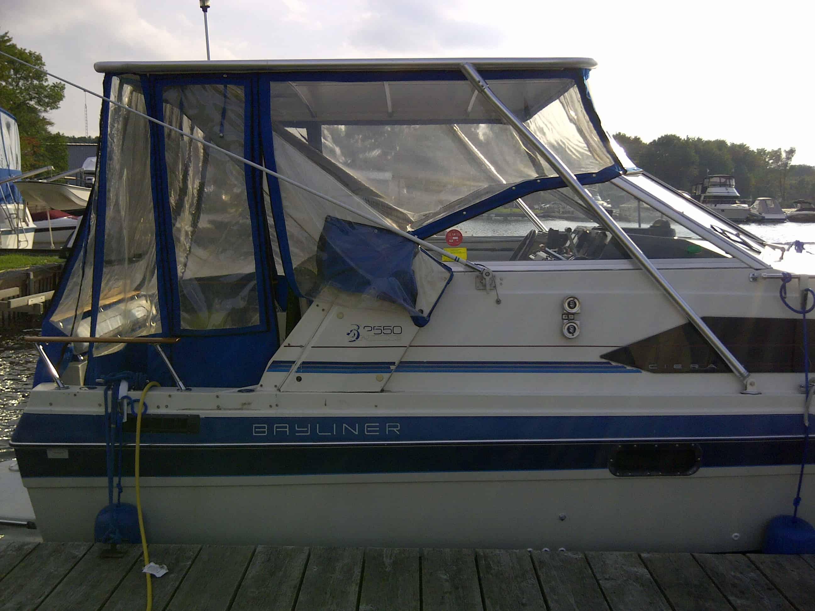 Atlantic Towers Bayliner 2550 Ciera cuddy boat docked with blue canvas and clear vinyl enclosure on cabin area