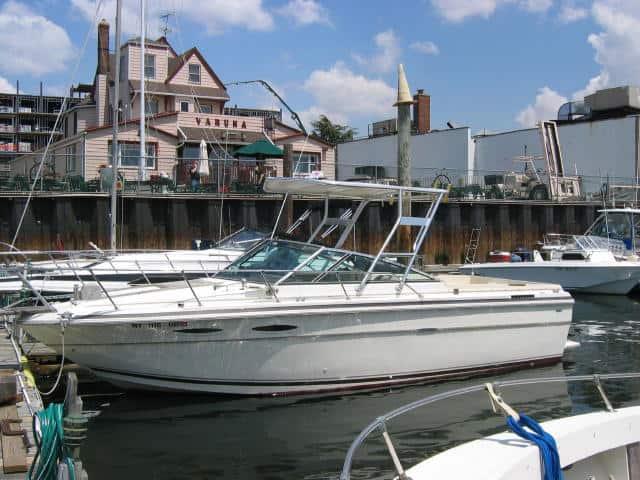 Atlantic Towers Top installed on a Sea Ray 245 boat docked in a marina with buildings in the background.