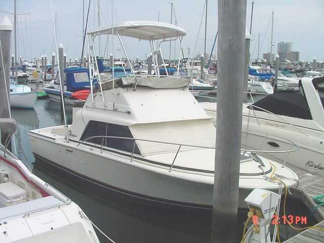 Phoenix 29 Convertible boat docked with Atlantic Towers Top installed, showing a covered upper helm station.