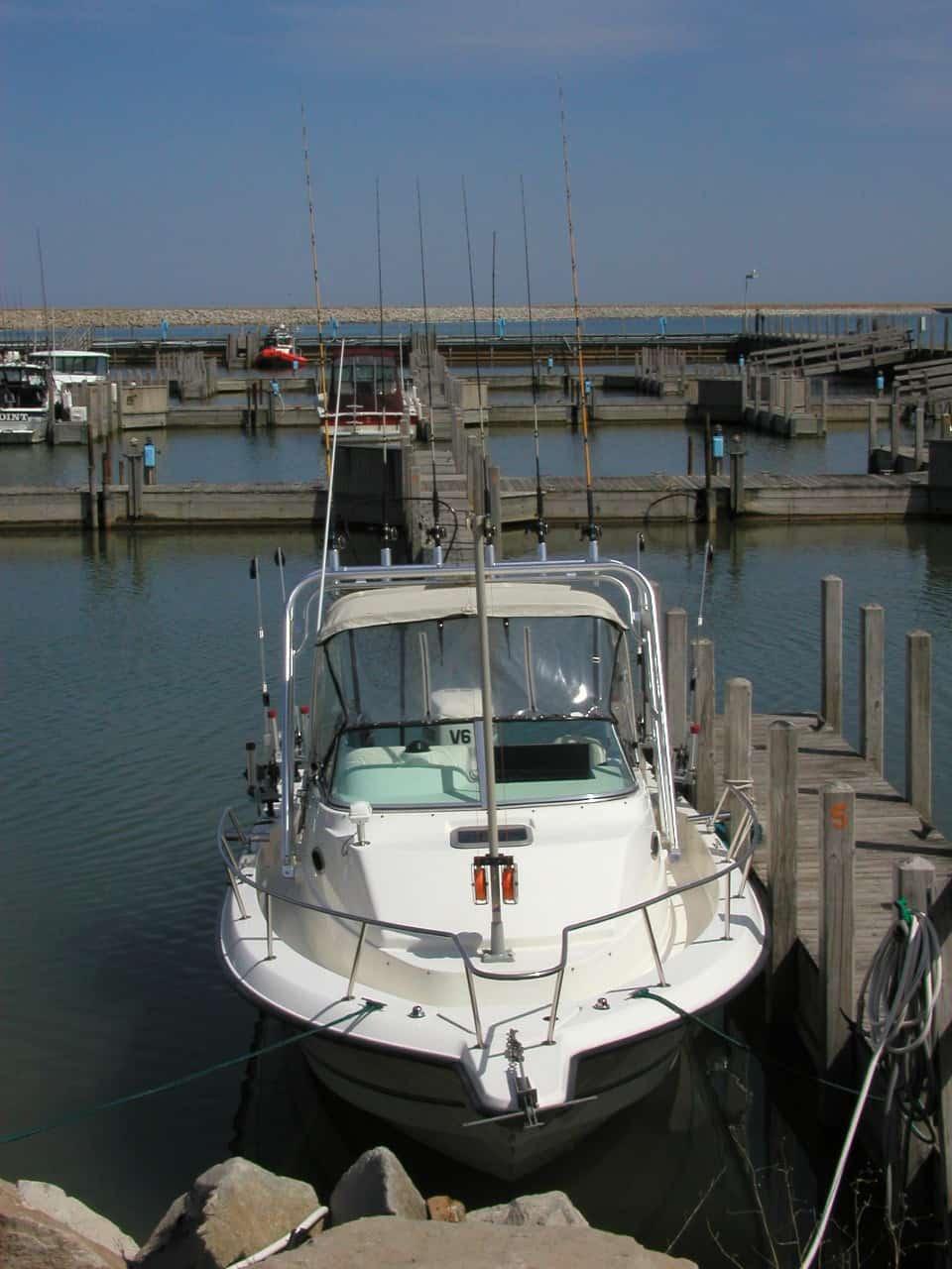 Atlantic Towers Arch on a Neptune 230 Sunbird boat docked in a marina surrounded by wooden docks.