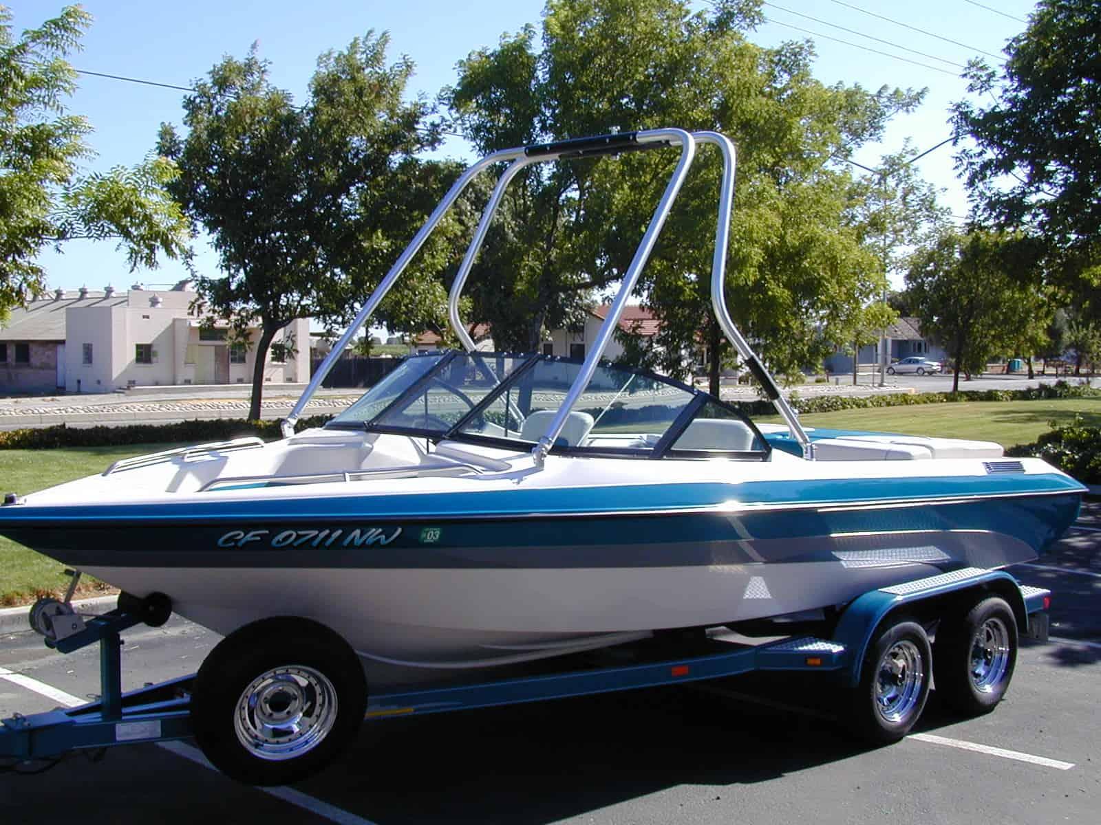 Atlantic Towers Air Tower installed on a Blue Water Boats Mirage, showcasing a bowrider design in a parking lot.