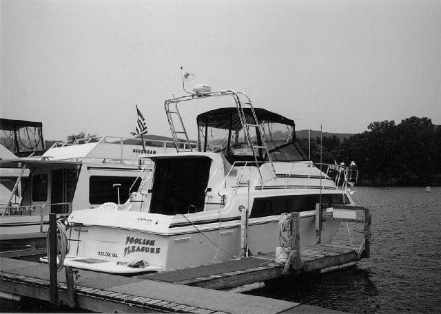 Atlantic Towers Arch installed on the Carver 32/330 Mariner boat docked at a marina with calm water and trees in the background