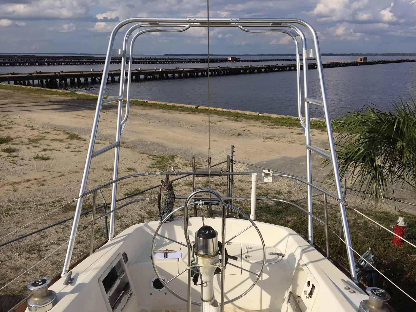View from the stern of a Tartan Yachts boat showing the installed Atlantic Towers arch and a steering wheel with a compass on board